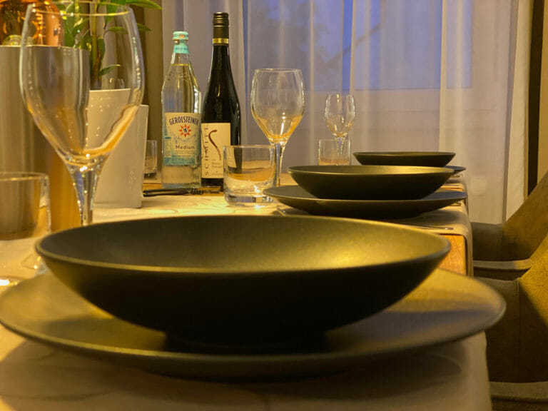 Gedeckter Esstisch mit Geschirr in schwarz matt