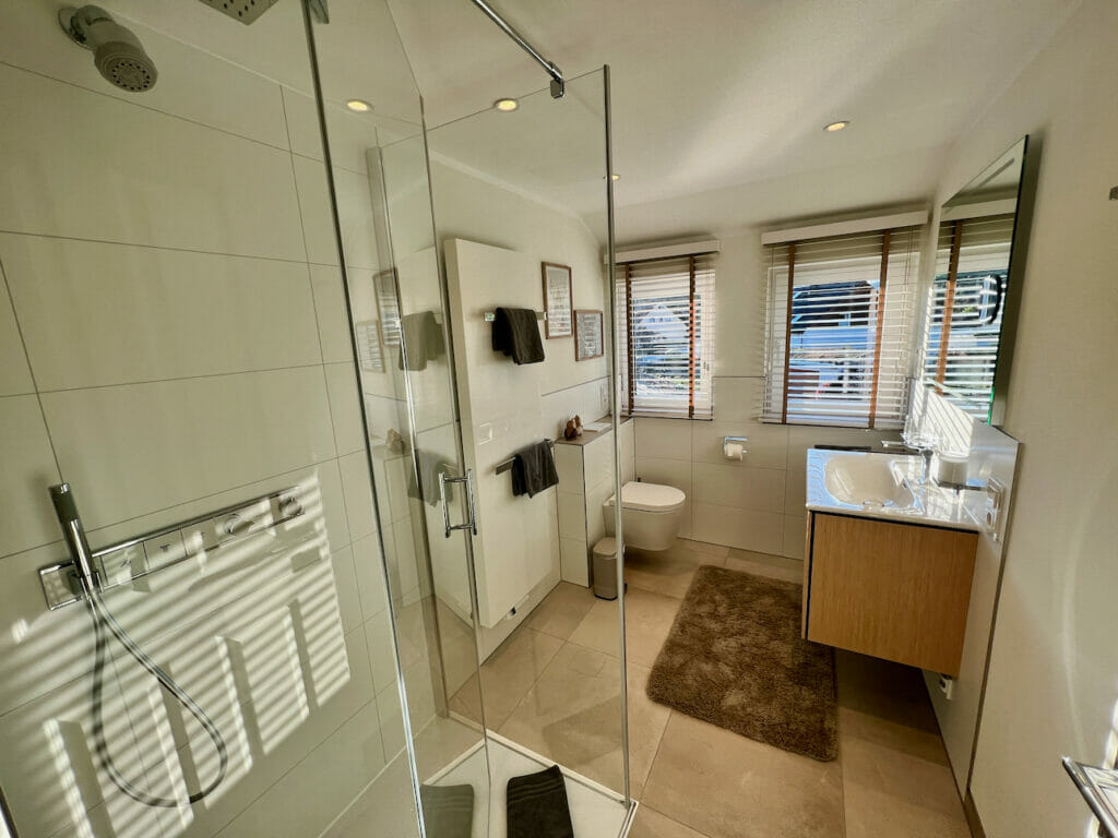 Modernes Badezimmer mit bodenbündiger Dusche, Waschtisch und WC
