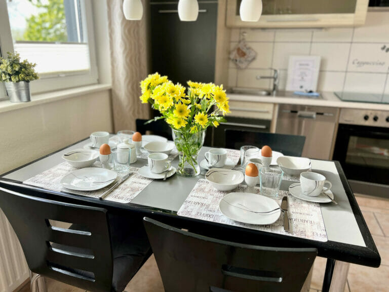 Wohnung Holiday 2 - gedeckter Frühstückstisch mit Blumen