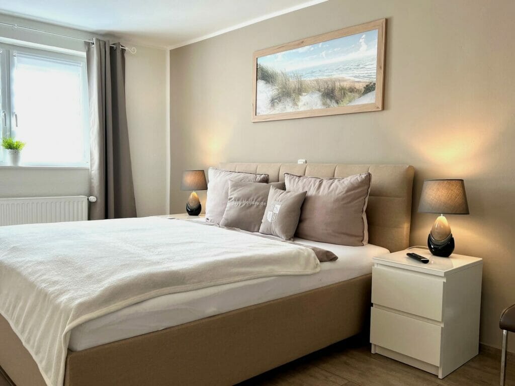 Wohnung Holiday 5 - Schlafzimmer mit Doppelbett in Komforthöhe beleuchtet