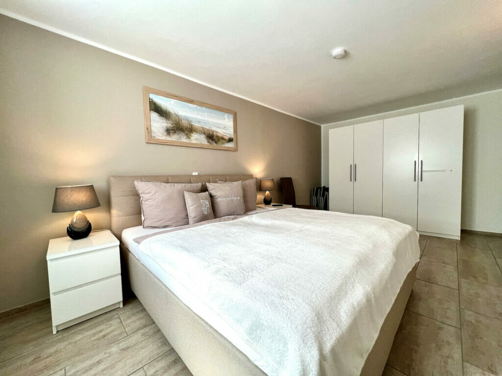 Wohnung Holiday 5 - Schlafzimmer mit Doppelbett in Komforthöhe und Kleiderschrank